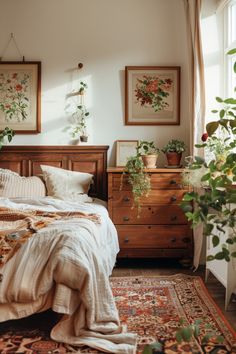 a bed sitting in a bedroom next to a window with plants on top of it