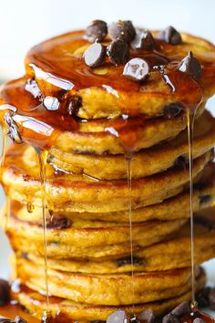 a stack of pancakes with syrup and chocolate chips on the side, drizzled with maple syrup