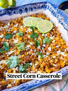 a casserole dish filled with corn and topped with cilantro, limes and parsley