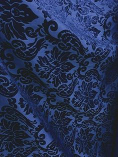 a blue and black fabric with an intricate design on the front, in very dark colors