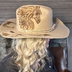 Cowboy hat custom burned by hand specifically for Bourbon Cowgirlby KC Lids. These hats are exclusive and only found here. We worked with the designer to create our very own look. 100% wool hat. One size fits all, as the interior band is adjustable to fit most. A beautiful cattleman rancher style, this distressed almond / beige colored hat is sanded and torched to a beautifully burnished and distressed finish. Firm shape (do not crush). Our artisan has hand burned a beautiful horse with flowing Custom Felt Hat For Country Events, Fitted Wool Hat For Rodeo, Country Style Fur Felt Hat, Fitted Wool Hat For Ranch, Felt Cap Hat For Country Events, One Size, Artisan Fitted Hats For Ranch, Fitted Wool Hats For Country Events, Felt Cap Hat For Country Events, Fitted Artisan Ranch Hats