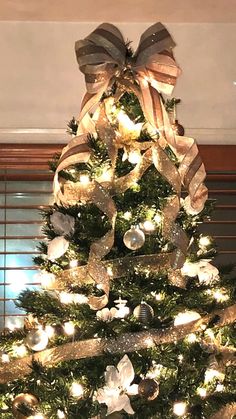 a decorated christmas tree with lights and bows