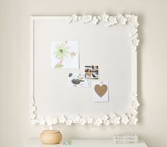 a white frame with flowers and pictures on it