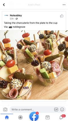 a wooden table topped with cups filled with different types of appetizers and toppings