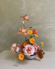 a vase filled with lots of different colored flowers