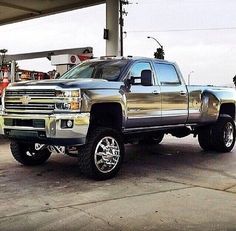 a silver truck parked in front of a gas station