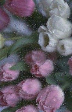 some flowers are sitting in the water on a window sill with raindrops