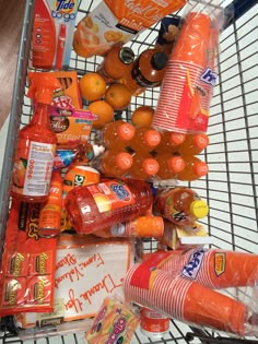 a shopping cart filled with lots of oranges and soda bottles on top of it