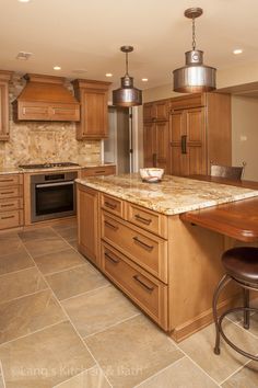 a kitchen with wooden cabinets and an island in the middle is shown, along with two stools