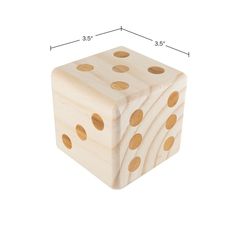 a wooden dice with gold polka dots on the side and measurements for each game piece