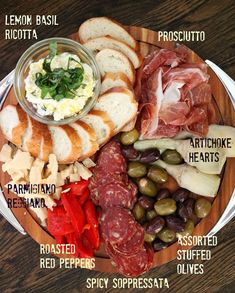 a plate with breads, olives, meats and cheeses on it