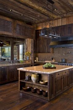 a large kitchen with wooden floors and an island in the middle, surrounded by dark wood cabinets