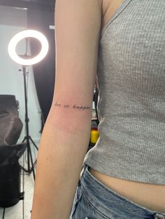 a woman with a small tattoo on her arm that says, i am the daughter