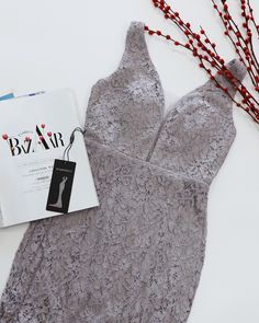 an open bra next to a book and some red stringy beads on a white surface