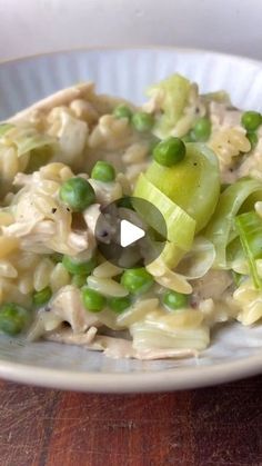 a white plate topped with pasta and peas