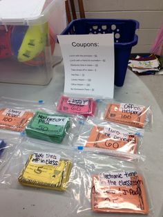 several packets of coupons sitting on top of a table next to a plastic container