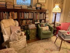 a living room filled with lots of furniture and bookshelves full of books on top of them