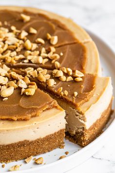 a cheesecake with nuts on top is cut into slices and sits on a plate