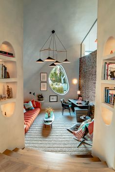 a living room filled with lots of furniture and bookshelves next to a window