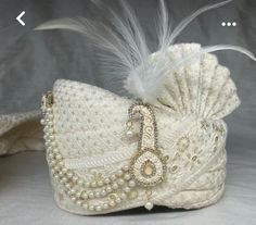 a white hat with feathers and beads on it