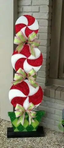 a candy cane christmas decoration on display in front of a brick wall and window sill