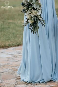 a woman in a blue dress holding a bouquet