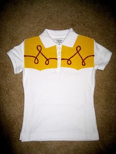 a white shirt with yellow and red details on the collar is laying on the floor