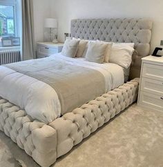 a bedroom with a large bed and white furniture