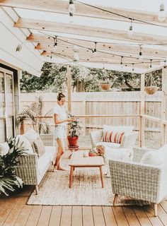 a woman is standing on the back porch