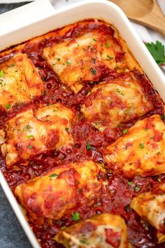 a casserole dish with meat and sauce in it, garnished with parsley