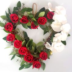 a heart shaped wreath with white and red roses