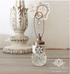 an old fashioned glass bottle with a clock on it sitting next to a white vase