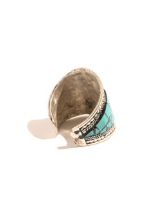 This adjustable white metal ring is hand-crafted by local artists of Nepal. It features the Om symbol in the center of the band, set off with turquoise stone chips and delicate ornate rope-like designs around both sides. The ring can be gently pressed together to adjust to whichever finger on which you choose to wear it. Measures almost 0.75 inches wide and 0.75 long. Handcrafted in Nepal.