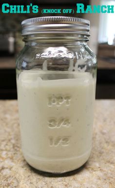 a glass jar filled with white liquid sitting on top of a counter