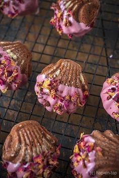 chocolate donuts with pink frosting and sprinkles on a cooling rack