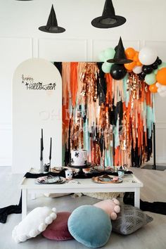 a table topped with lots of different types of balloons and hats on top of it