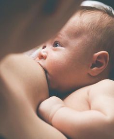 a close up of a person holding a baby in their arms and touching it's face