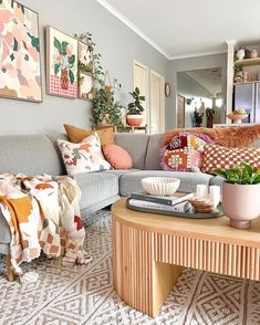 a living room filled with lots of furniture and paintings on the wall above it's coffee table