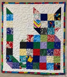 a colorful quilt is hanging on the wall