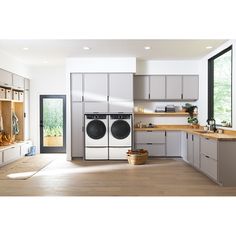 a laundry room with washer, dryer and cabinets in the middle of it