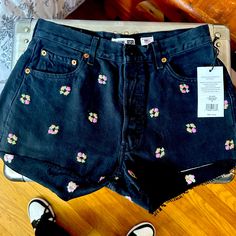 Cute Black Jean Shorts With Embroidered Flower Design. Mid-rise Cotton Bottoms With Floral Print, Mid-rise Cotton Floral Print Bottoms, Mid-rise Floral Print Cotton Bottoms, Black Embroidered Cotton Shorts, Trendy Cotton Bottoms With Floral Embroidery, Fitted Cotton Shorts With Floral Embroidery, Black Bottoms With Floral Embroidery For Summer, Trendy Cotton Floral Embroidered Bottoms, Black Floral Embroidered Bottoms For Summer