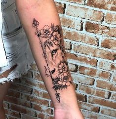 a woman's arm with a lion and flowers on it