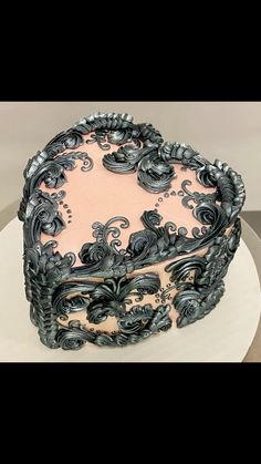 there is a cake that has been decorated with black and pink icing on it