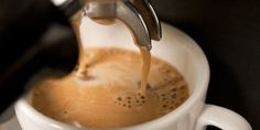 coffee being poured into a white cup