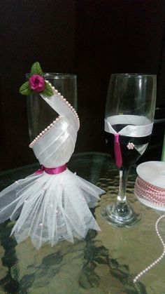 two wine glasses on a table with one glass and the other is decorated like a dress