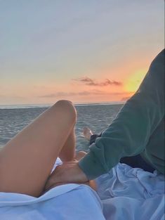 two people sitting on the back of a boat in the ocean watching the sun go down