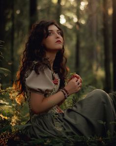 a woman sitting in the woods with her eyes closed