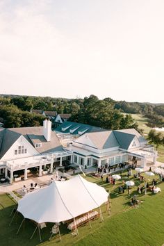 an aerial view of a large white house with tents set up on the lawn in front of it