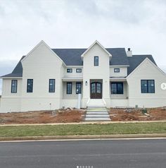 a large white house sitting on the side of a road