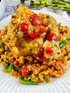 a white plate topped with rice covered in meat and veggies